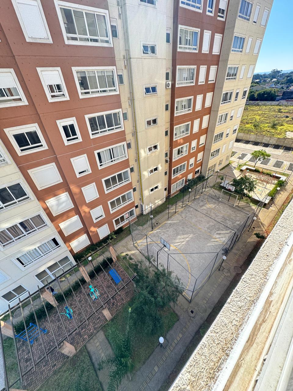 Vista aérea do condomínio com quadra, playground e prédios